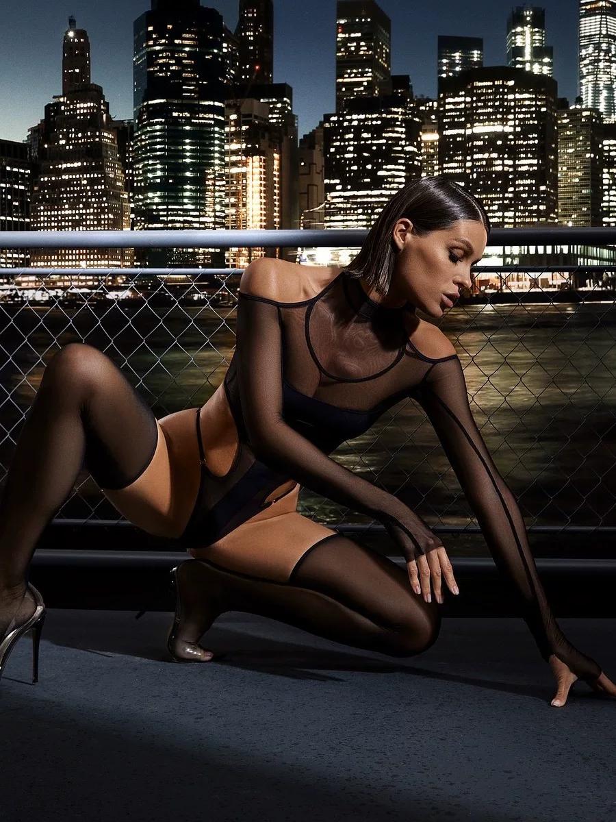 Full-length view of black sheer long sleeve bodystocking with attached thigh-high stockings on 165 cm frame