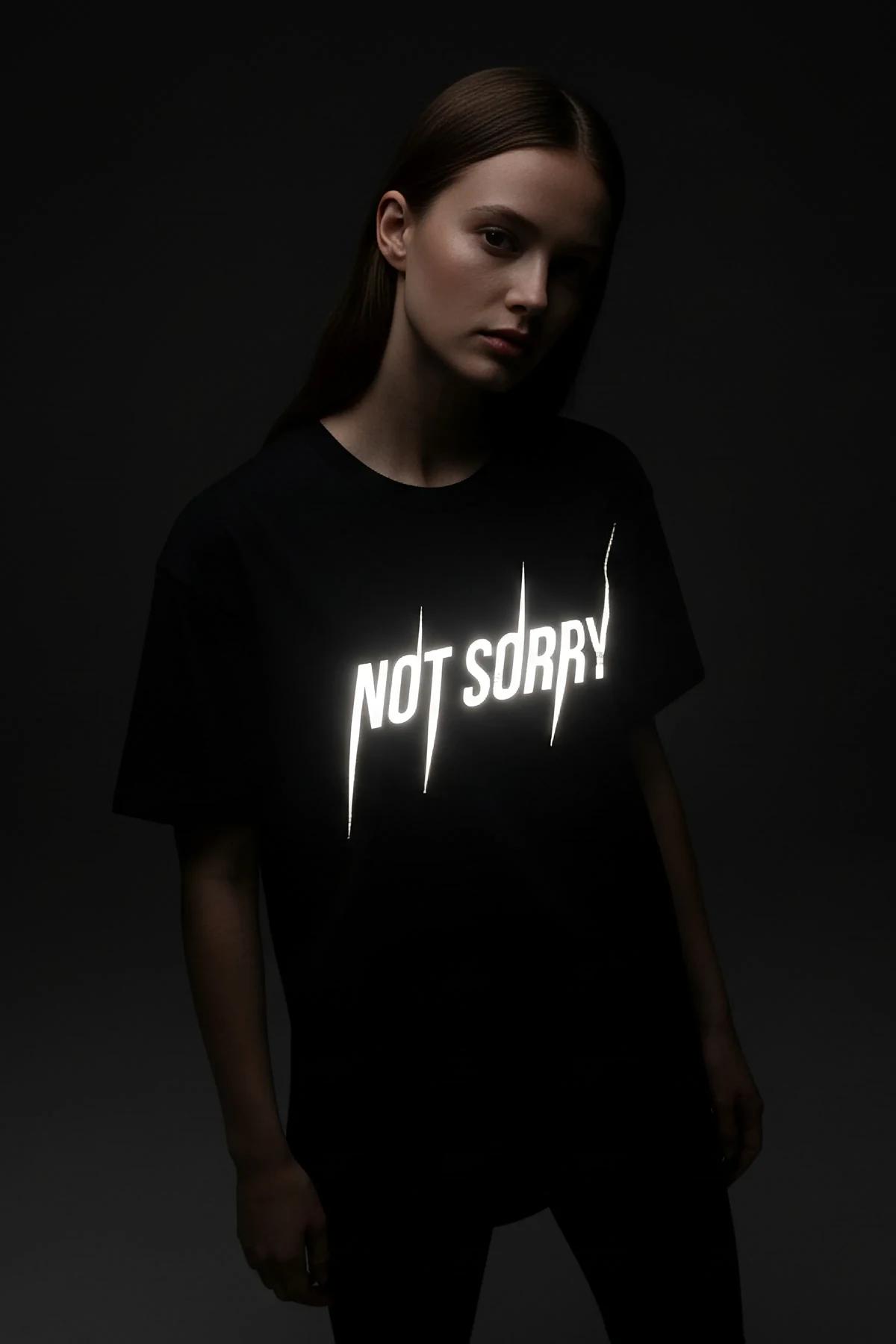 NOT SORRY reflektörlü ön baskılı siyah oversize tişört karanlıkta parlayan görünüm