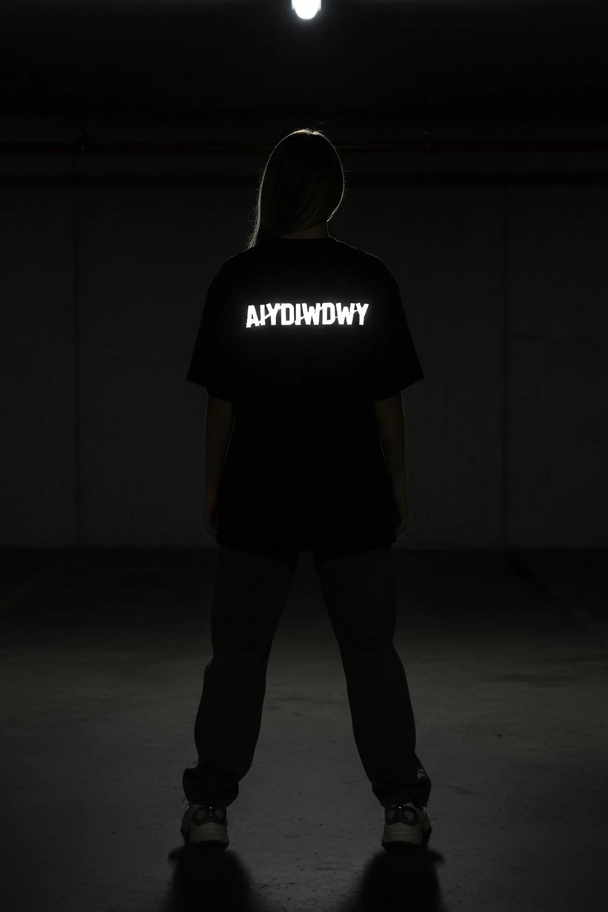 detail shot of 28 cm wide reflective block-letter print on heavyweight black cotton festival t-shirt