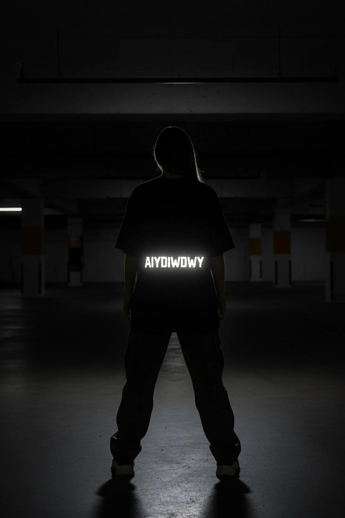 black reflective graphic tee styled with dark cargo trousers and chunky boots streetwear night look