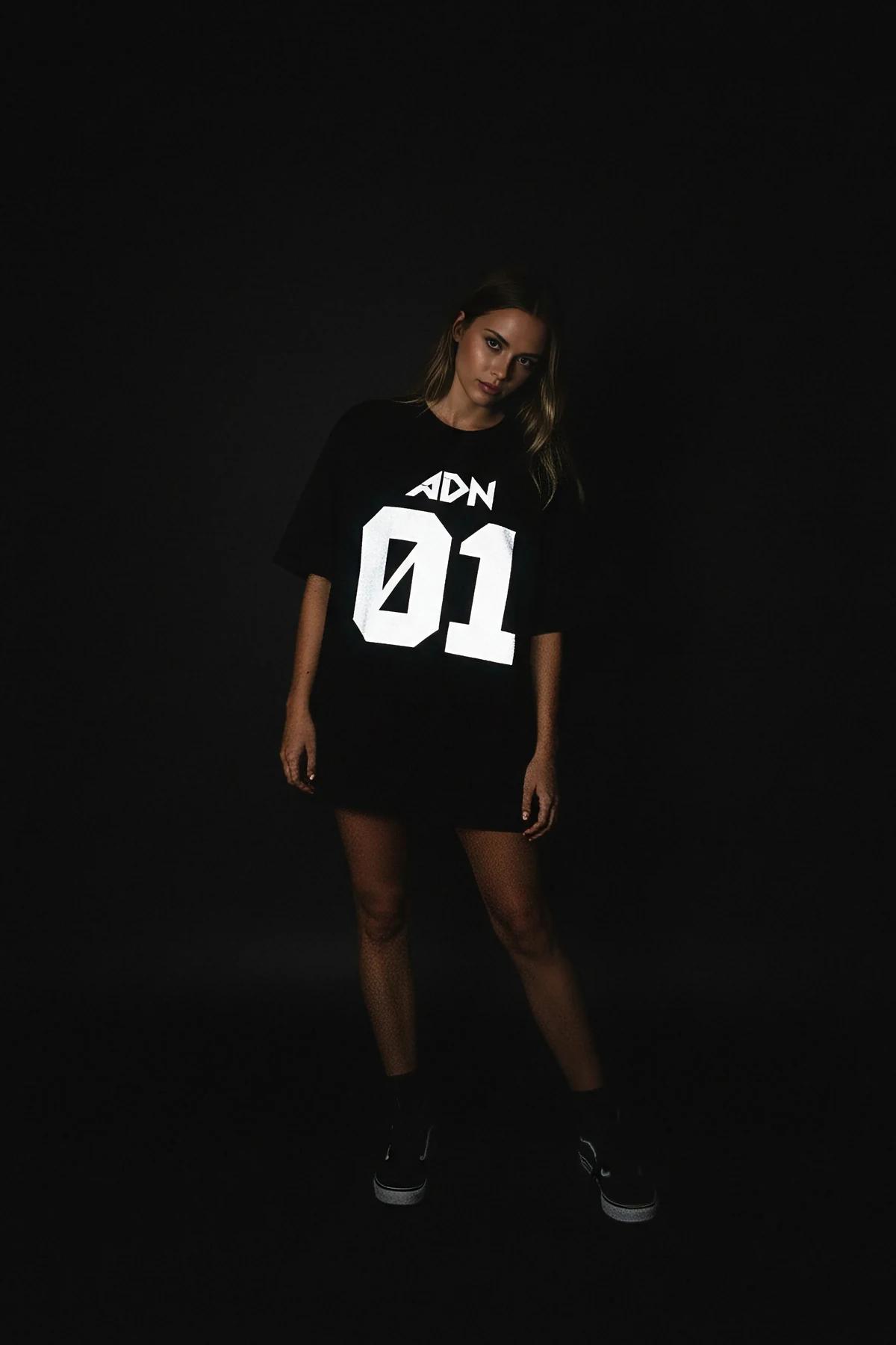 Front view black oversized cotton tee with large retroreflective chest graphic in graffiti style