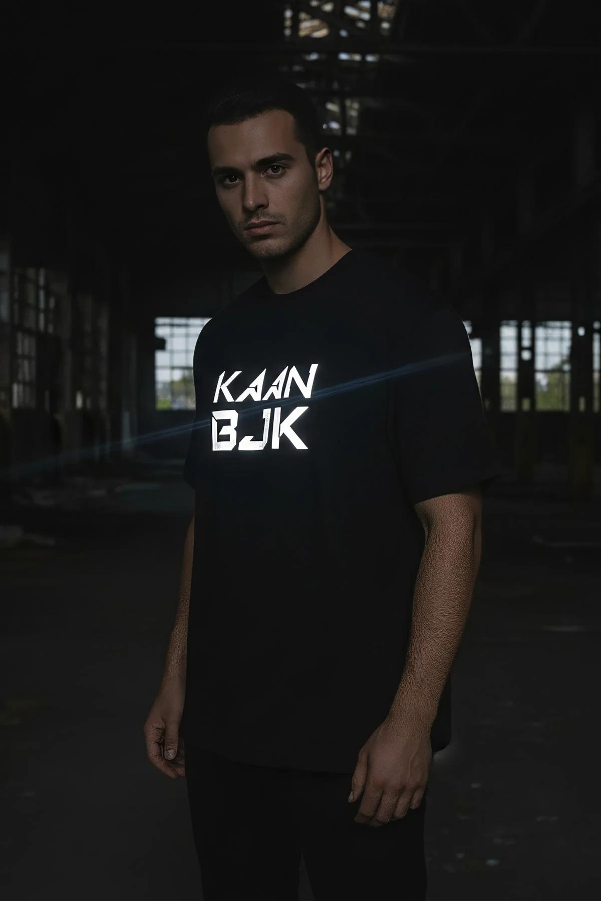 full length shot of men's black drop-shoulder tee with bold reflective lettering print