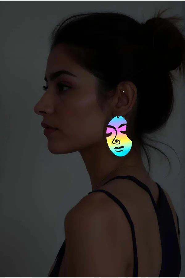 Gökkuşağı reflektörlü lazer kesim soyut kadın yüzü küpe mavi sarı pembe renk geçişi karanlık fotoğraf