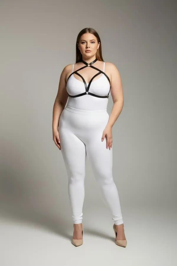 Black faux leather strappy cage chest harness with silver O-ring, adjustable crossing straps, worn over white bodysuit