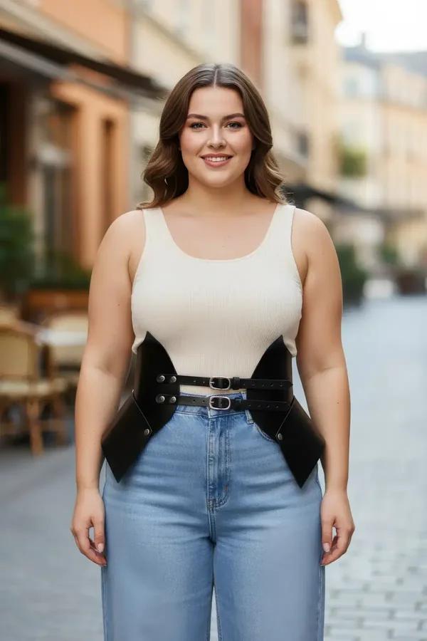 Black faux leather structured waist cinch harness with angular side panels and double silver buckle worn over cream tank top 