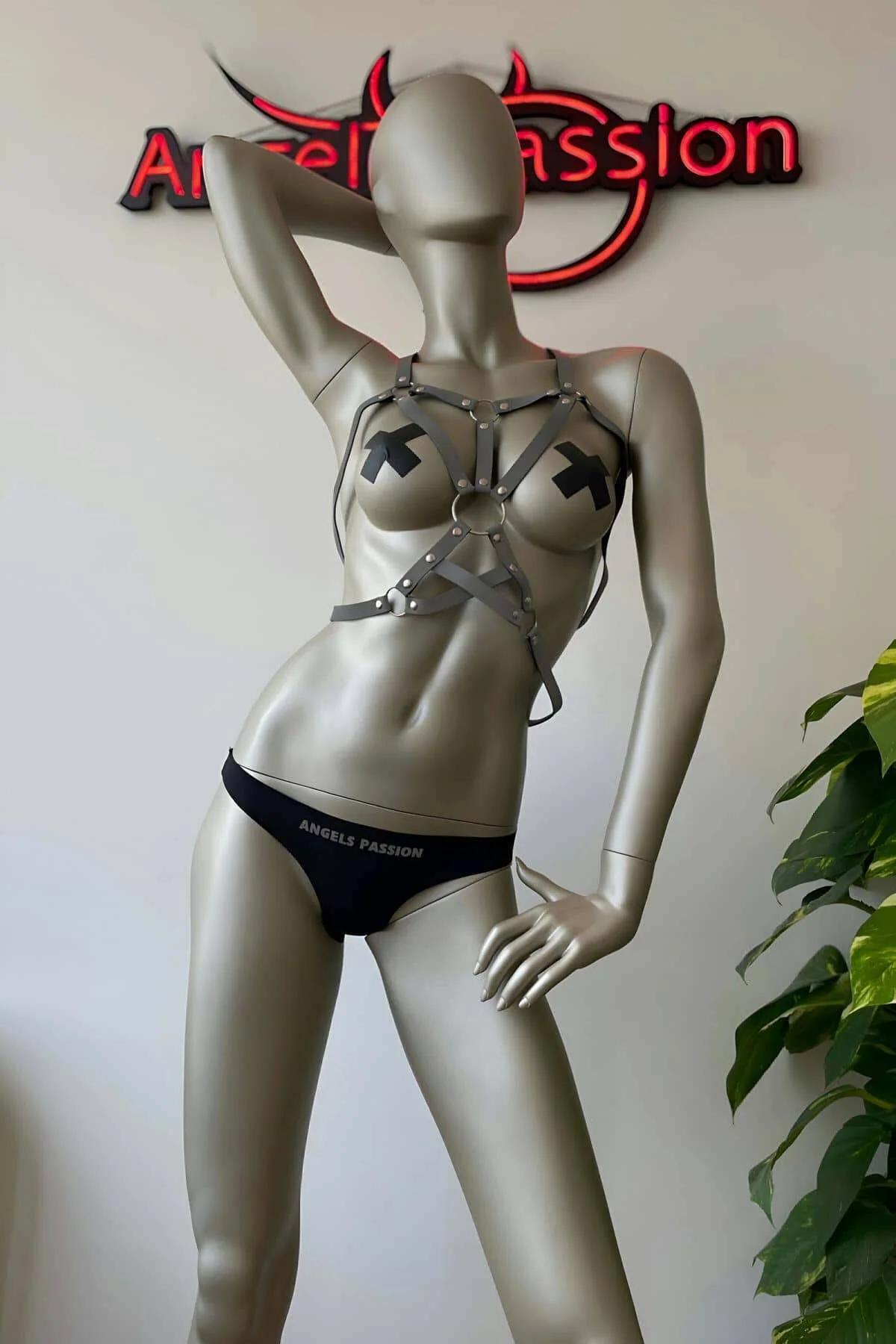 Close-up of white reflective strap width and silver zinc alloy rivet closures on geometric chest harness
