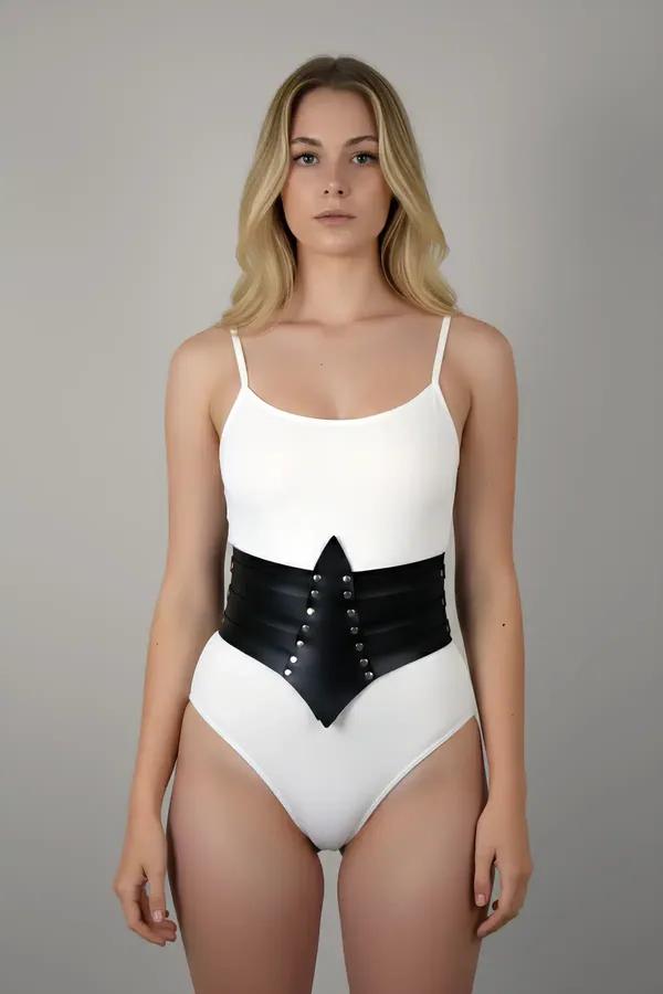 Black faux leather studded waspie waist harness belt with V-front panel worn over white bodysuit