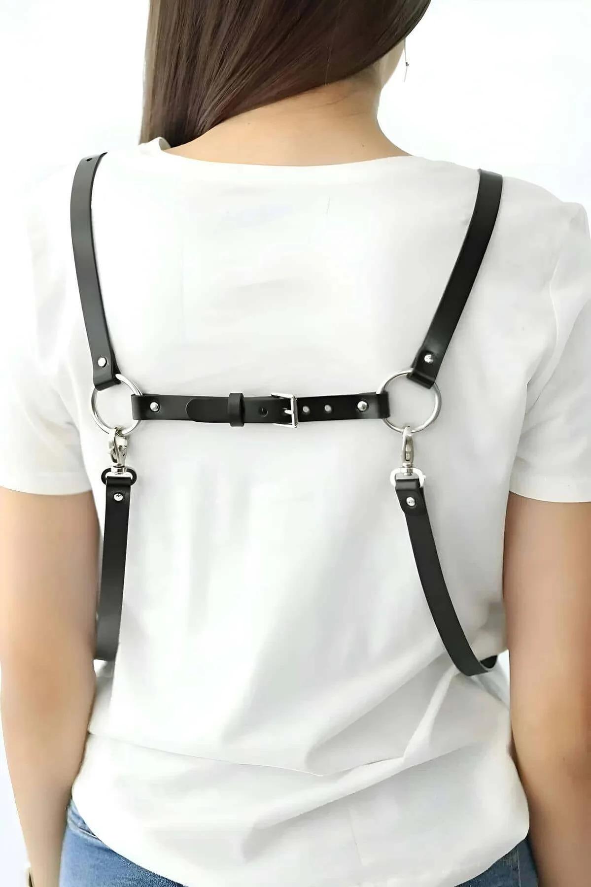 Side angle of black strappy chest harness showing adjustable shoulder strap length and dangling tails