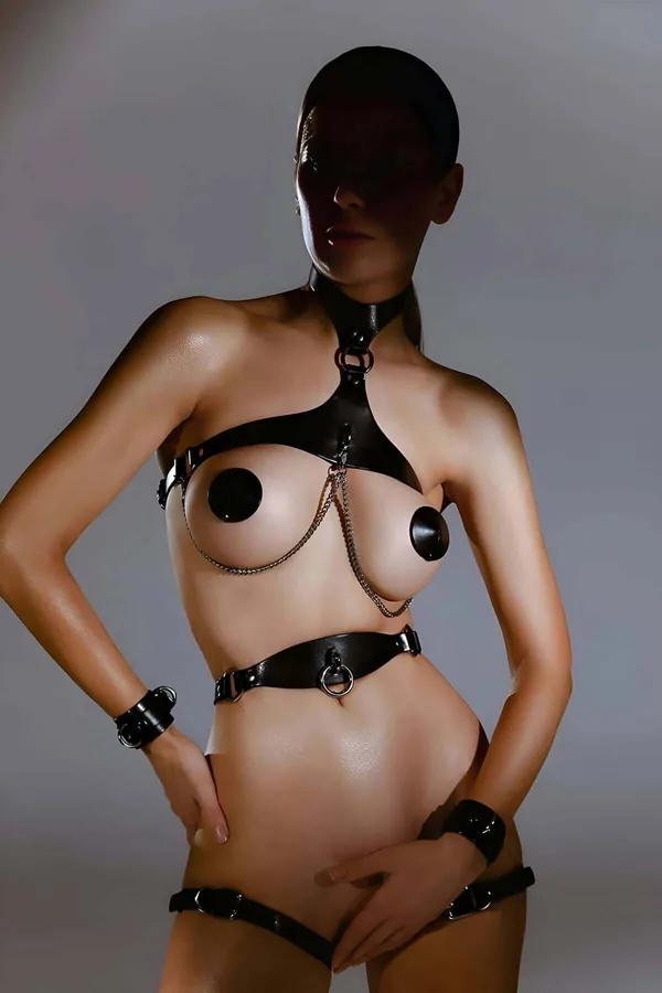 black faux leather full body harness with silver O-rings and double chain drape — collar, chest panel, waist belt, and thigh 