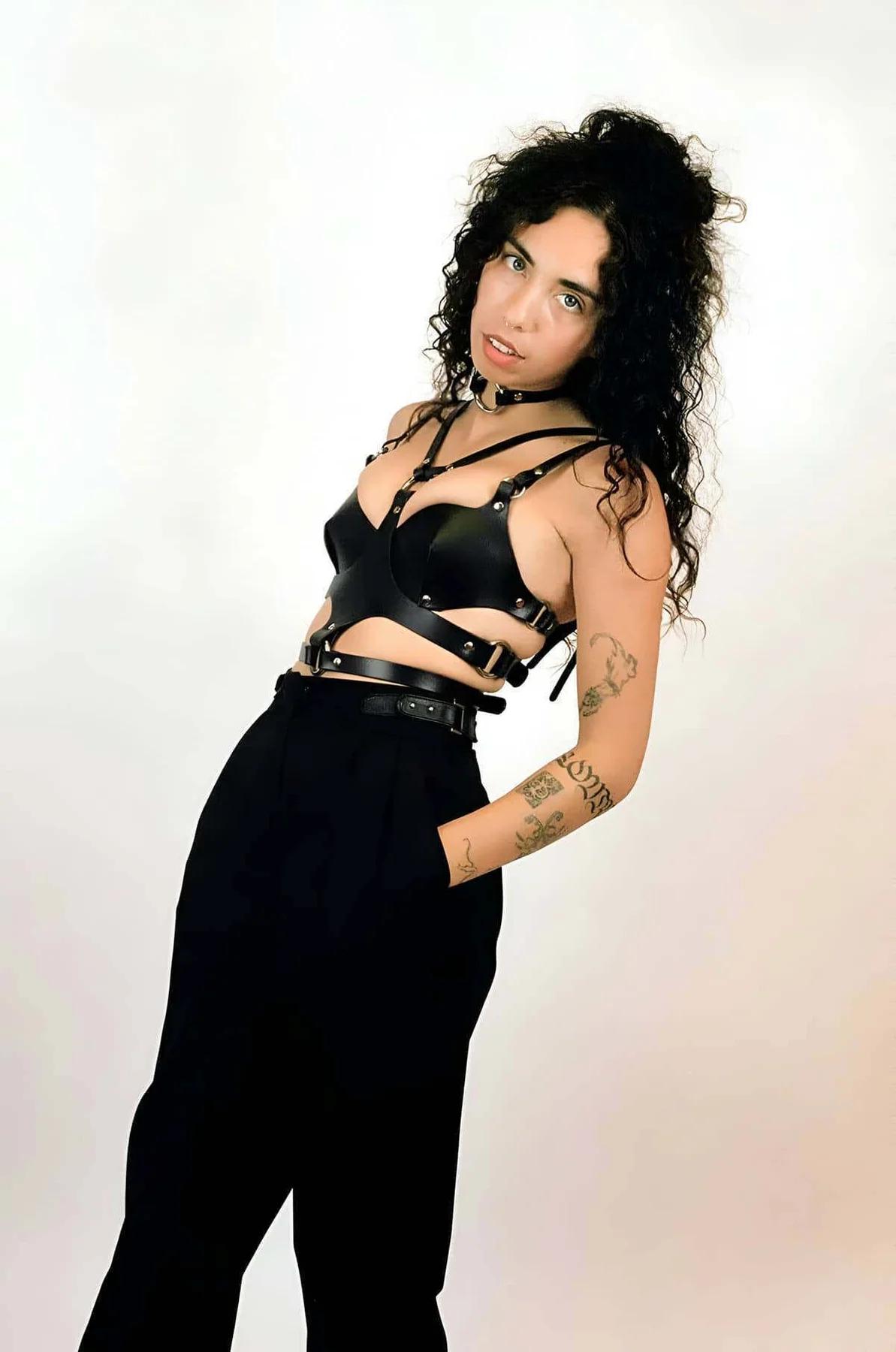 Front detail of black PU leather harness showing V-strap shoulder configuration and central chest O-ring