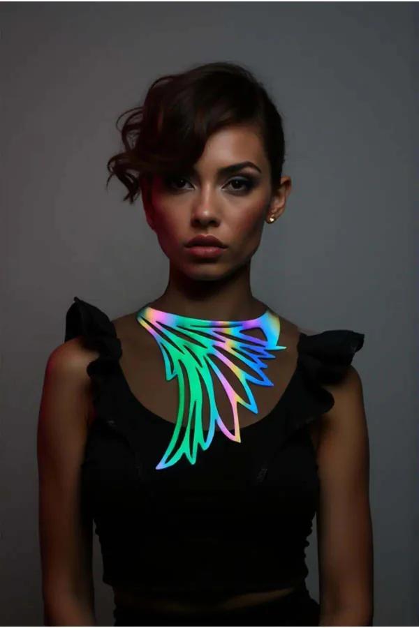 Iridescent holographic wing choker necklace in rainbow color shift worn across collarbone over black top