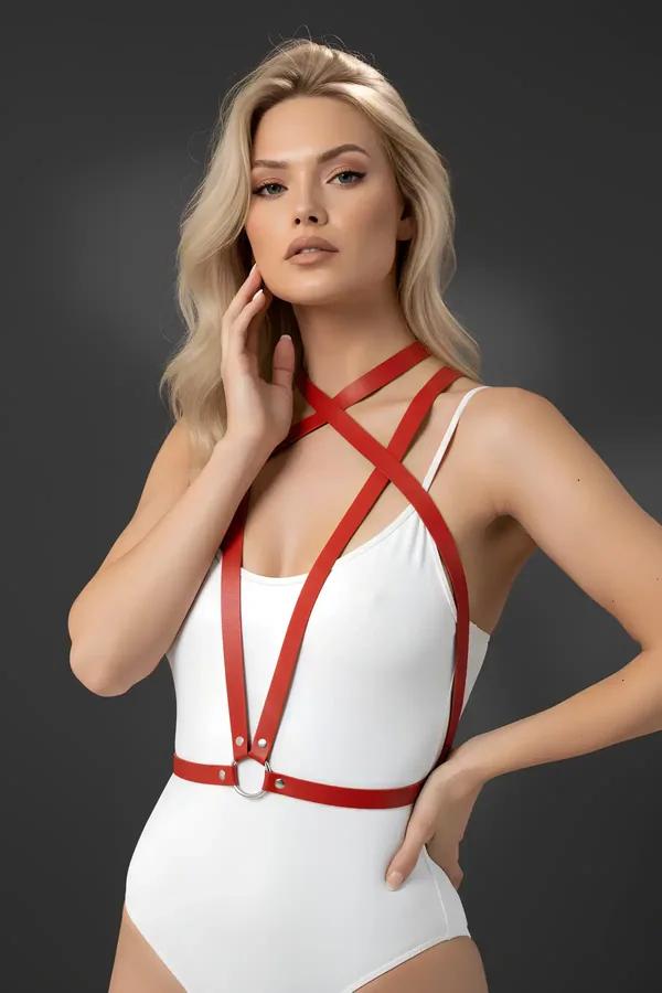 Minimalist red faux leather body harness with X-cross chest straps and silver O-ring waistband worn over white bodysuit