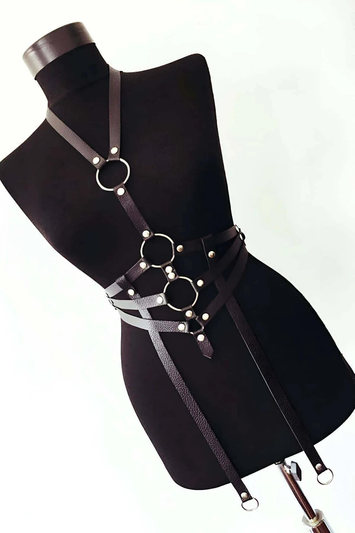 Close-up of three stacked silver O-rings on black faux leather waist band with dome studs