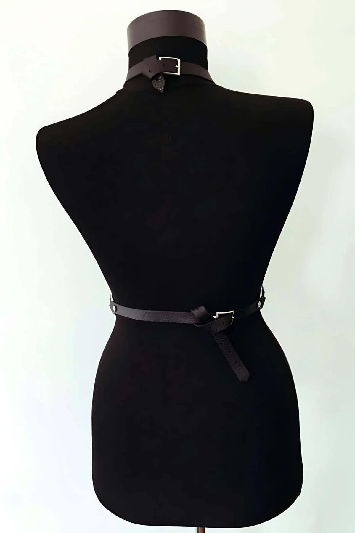 Side view of black body harness showing diagonal shoulder strap and vertical hip straps with D-ring adjusters