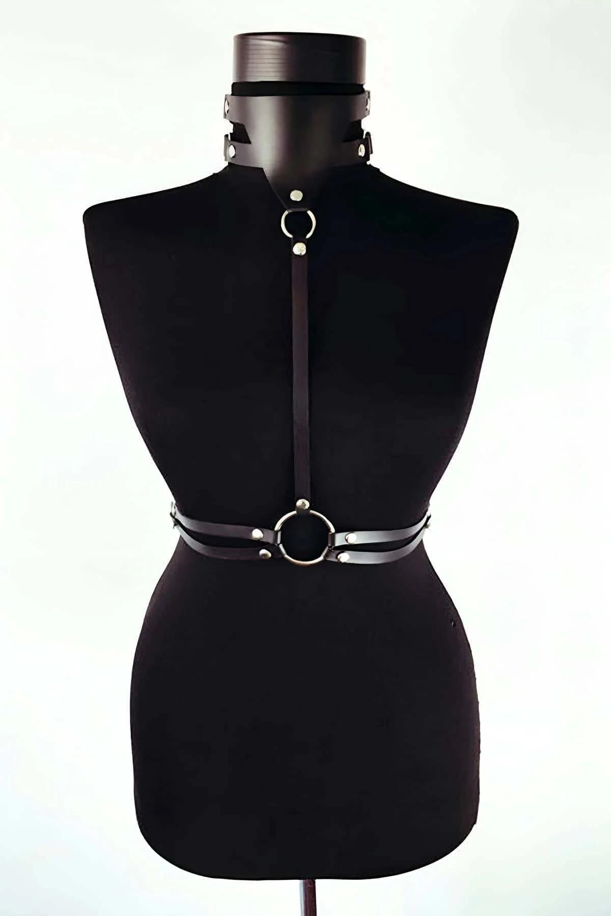 Detail shot of large silver O-ring at waist band on black matte faux leather harness