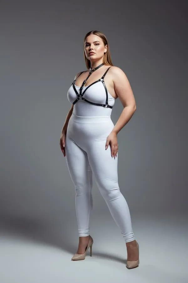Black faux leather strappy chest harness with silver buckles and collar band worn over white outfit