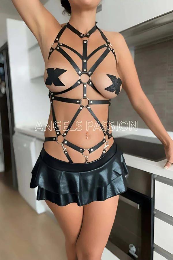 Black faux leather caged full body harness with multiple silver O-rings and stud hardware crossing at chest and waist