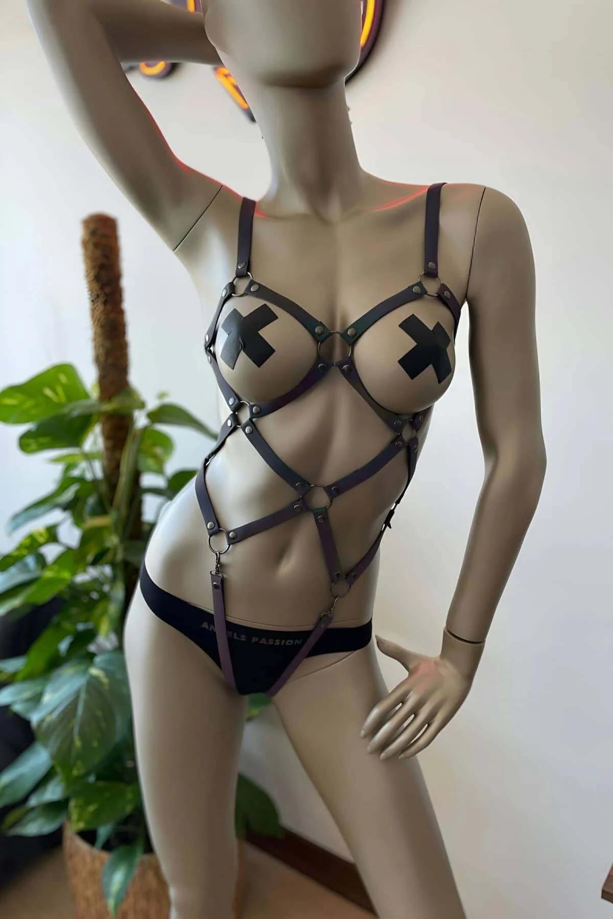 Holographic rainbow cage harness front view showing seven-strap geometric chest panel and waist O-ring
