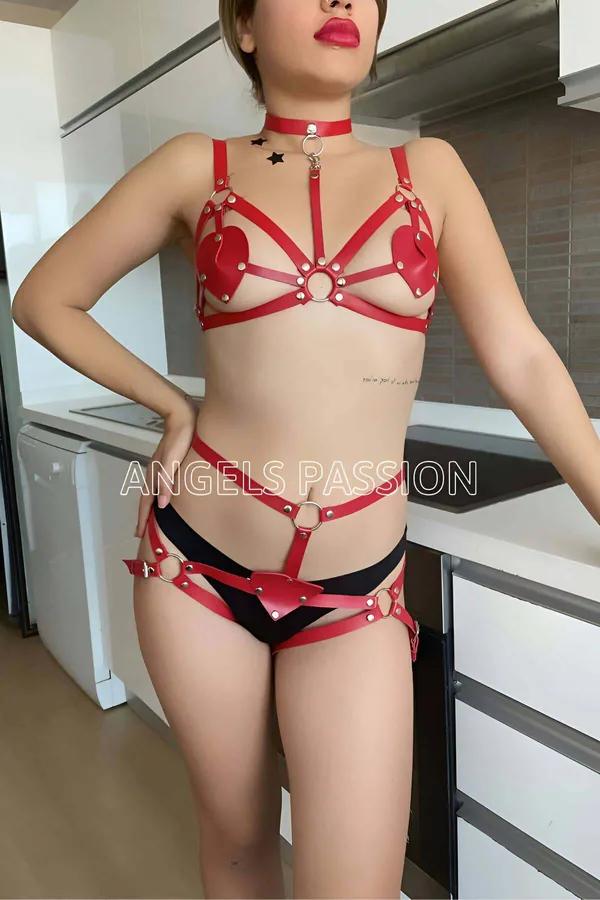 Red faux leather heart detail body harness lingerie set with silver O-rings, studded straps, choker, and hip harness