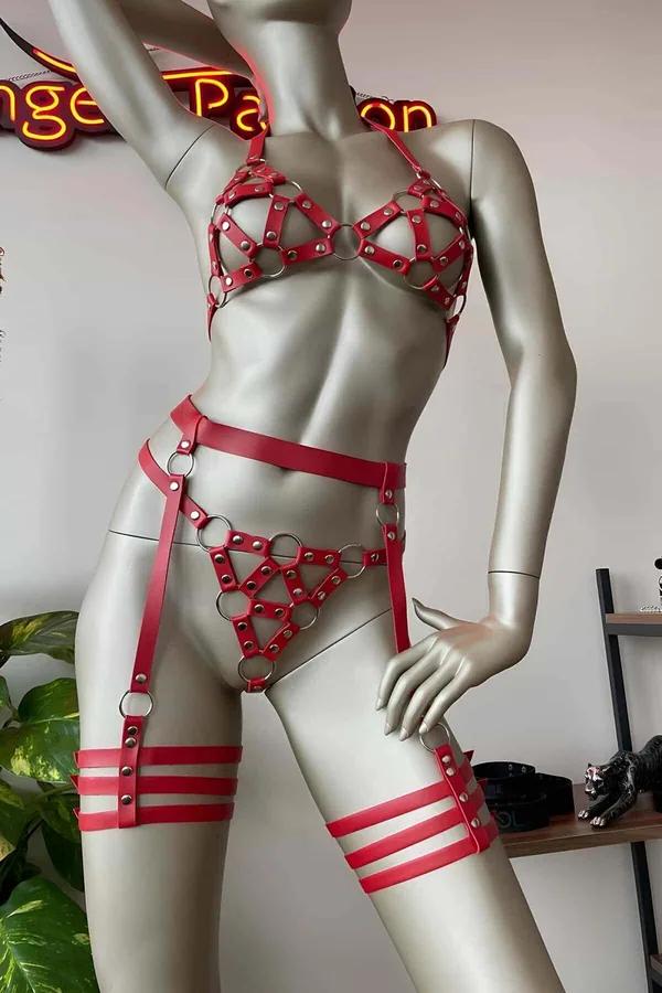 Red faux leather caged O-ring body harness and garter set with silver hardware on mannequin, four-piece view