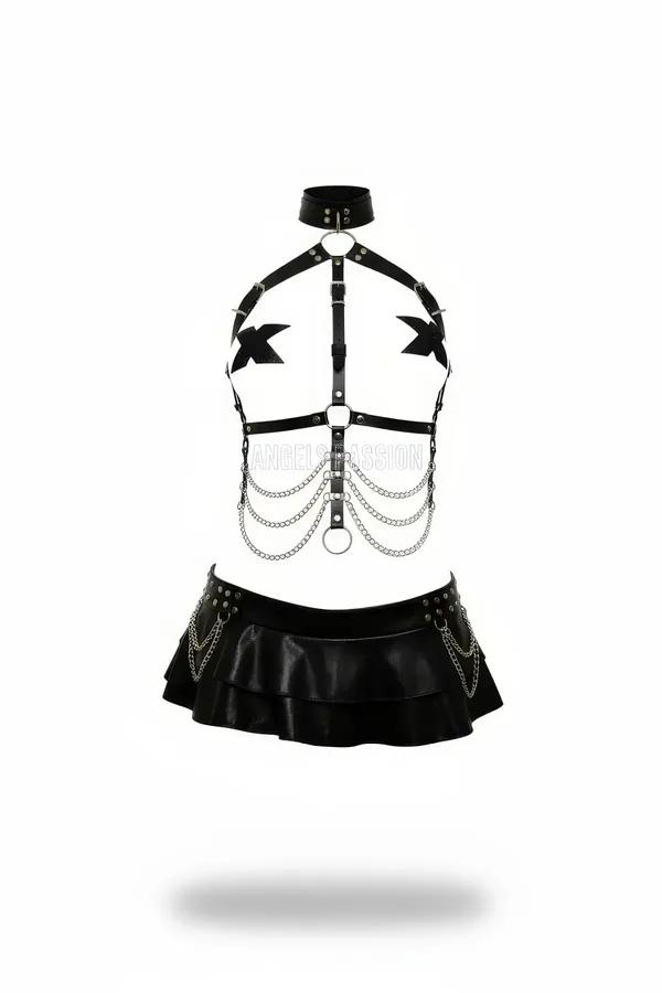 Black faux leather choker harness and tiered mini skirt set with silver O-rings draped chains and rivet detailing on white ba