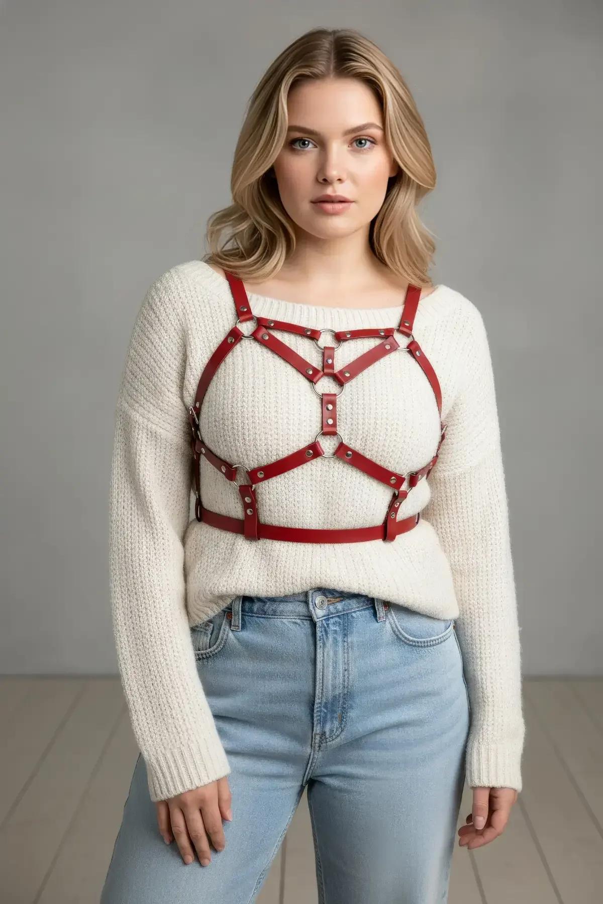 red faux leather fashion harness waist band and O-ring detail close up on silver rivet studs
