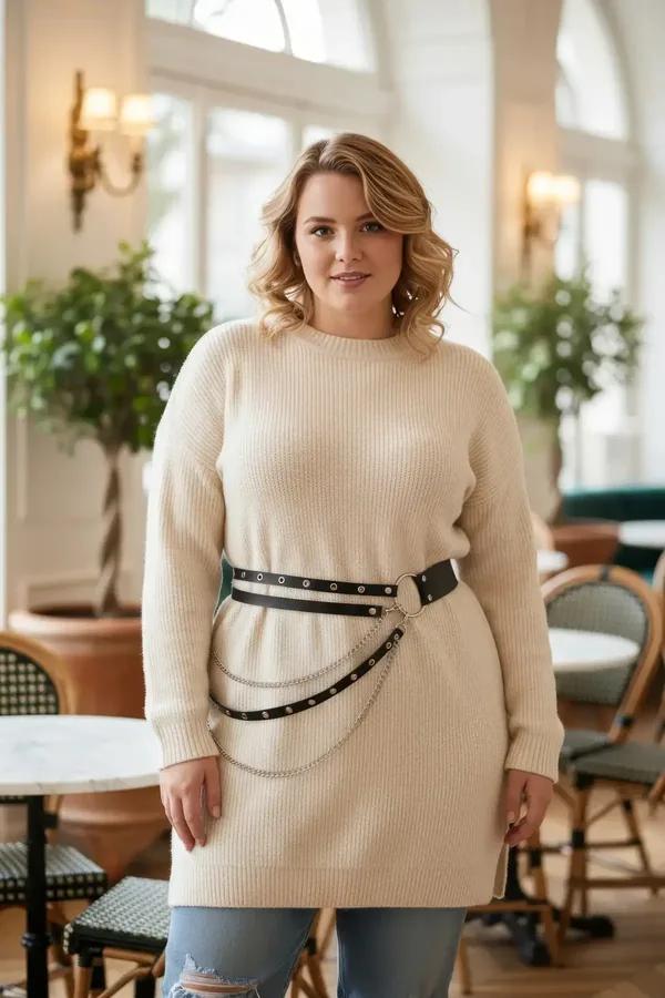 Black faux leather double-row studded belt with silver O-ring and chain drapes worn over a cream knit sweater dress
