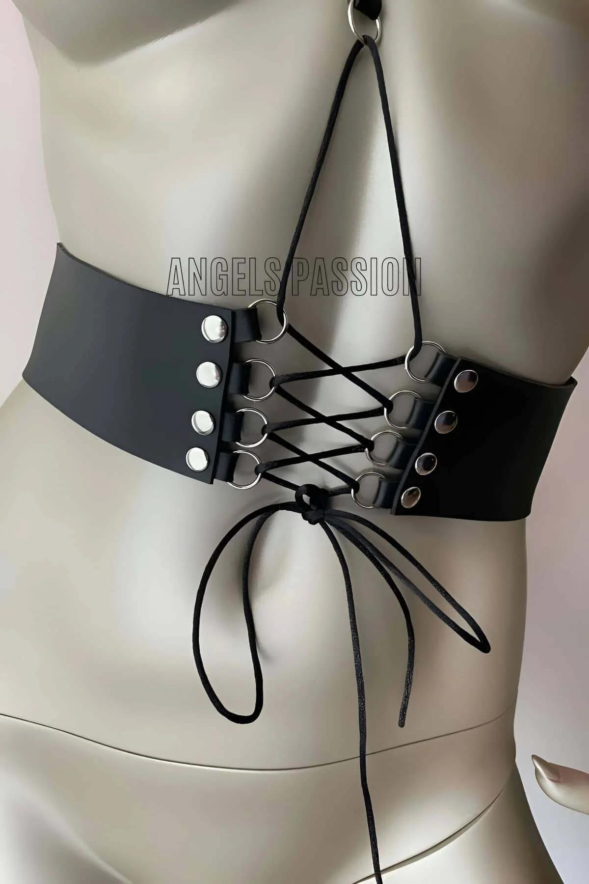 Close-up of black faux leather corset waist panel with silver metal grommets and thin cord lace