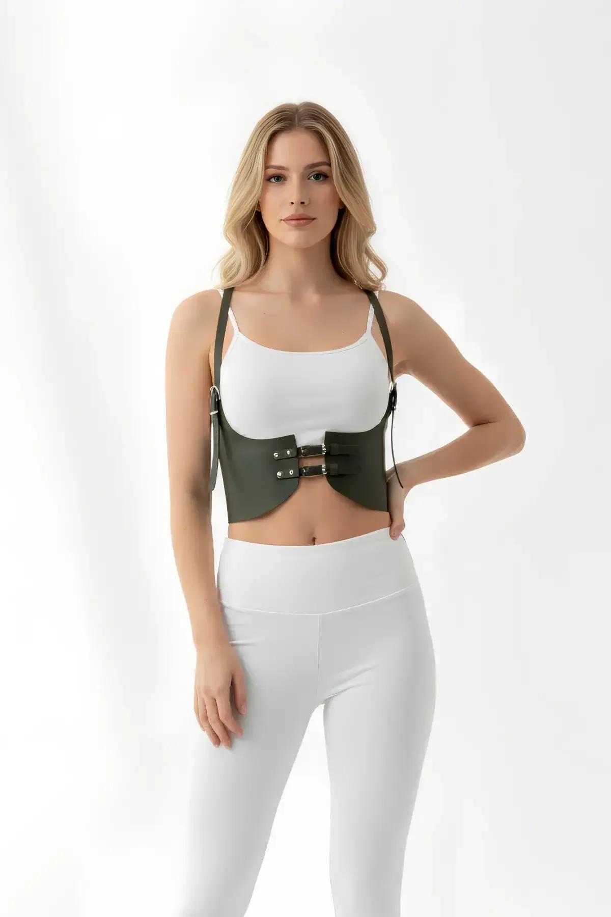 Olive green faux leather harness cincher layered over white tank top with white trousers streetwear styling