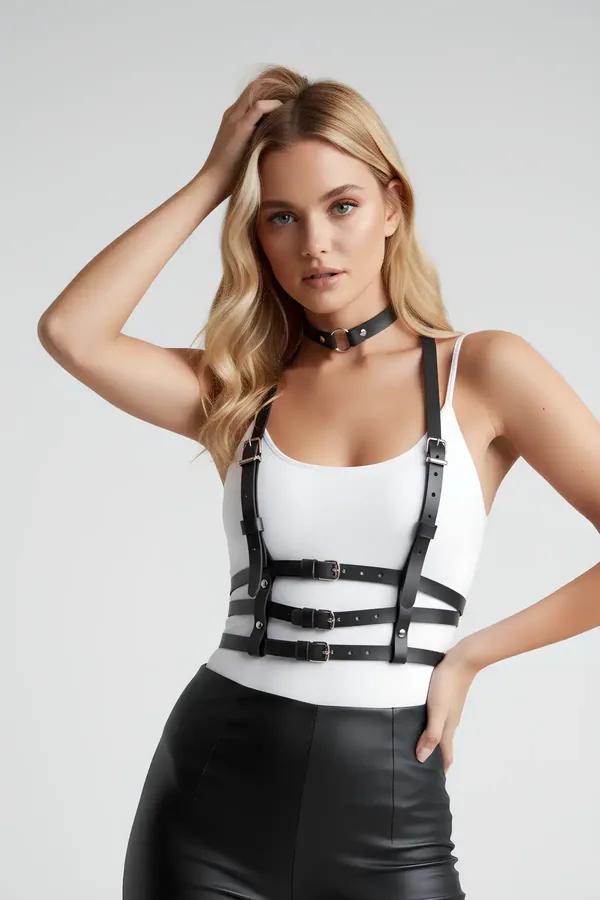 Black faux leather chest harness with three silver-buckle bands and matching O-ring choker worn over white bodysuit