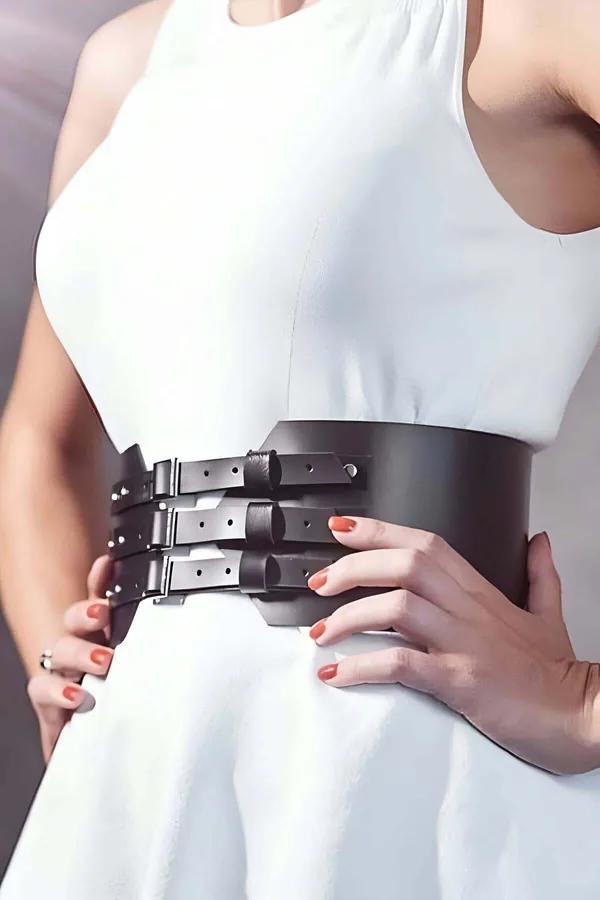 wide black faux leather corset belt 3 silver buckle detail waist-cinching structure over white dress