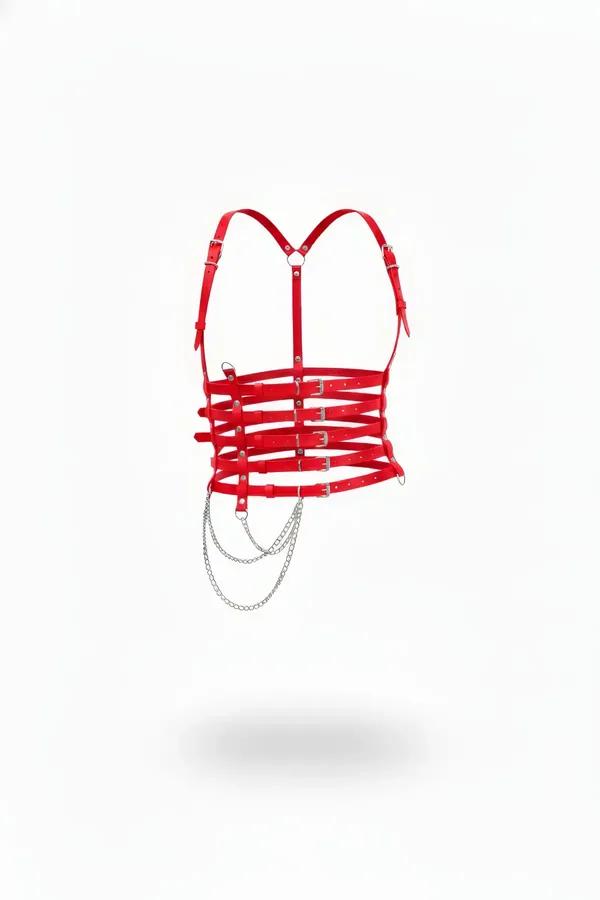 Red faux leather chest harness with five horizontal cage straps, silver pin buckles, and draped silver-tone chain on white ba