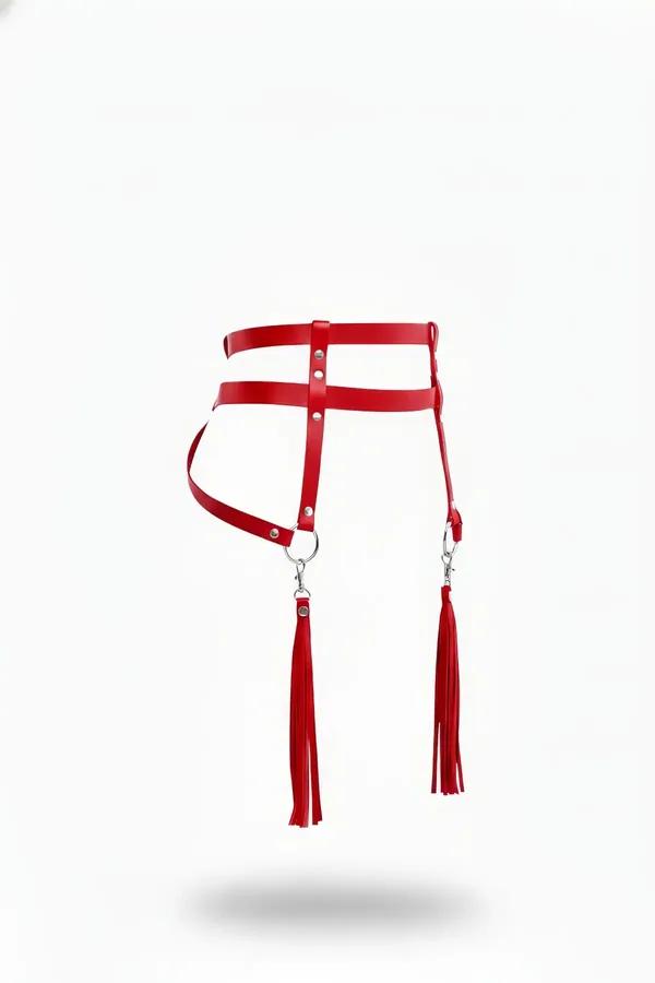 red faux leather double-strap waist harness with detachable tassel charms on silver O-rings, flat white background