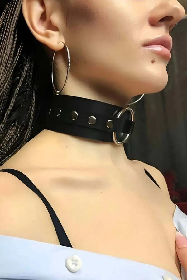 black faux leather wide choker collar with silver O-ring and snap studs worn on neck