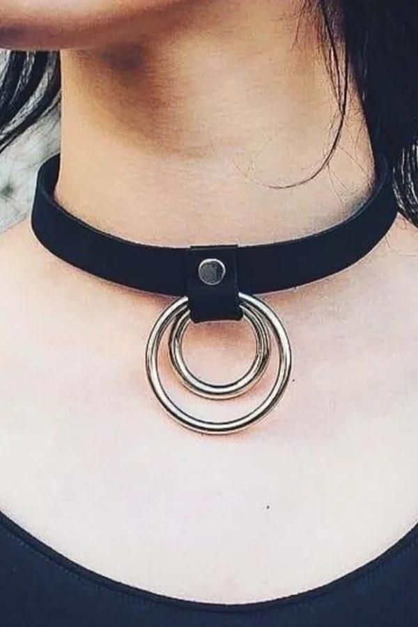 black faux leather choker with two concentric silver O-rings riveted at center front worn at neck