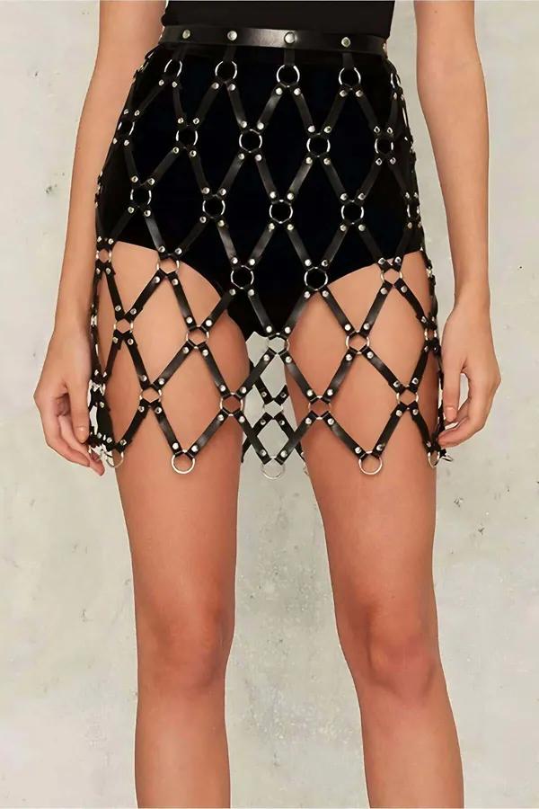 Black faux leather grid skirt harness with silver O-rings and dome-head rivets at each diamond crossing, worn at natural wais