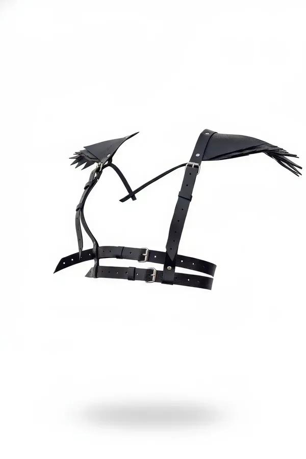 Black faux leather winged shoulder harness with fringed epaulettes and silver pin-buckles, front view on white background