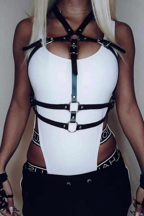 Black faux leather strappy chest harness with two stacked silver O-rings and adjustable buckle straps worn over white top