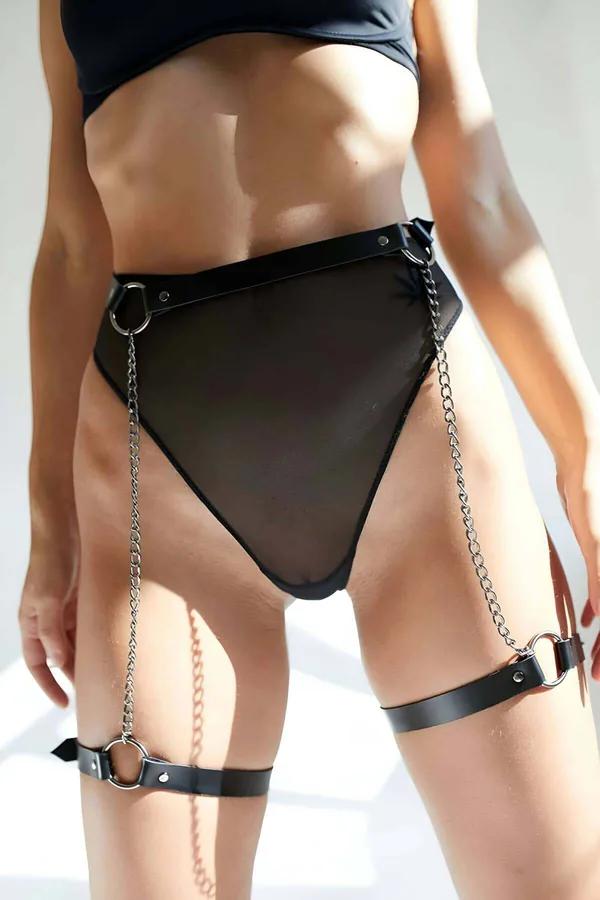 Black faux leather leg harness with dual silver chains and O-ring thigh cuff on model