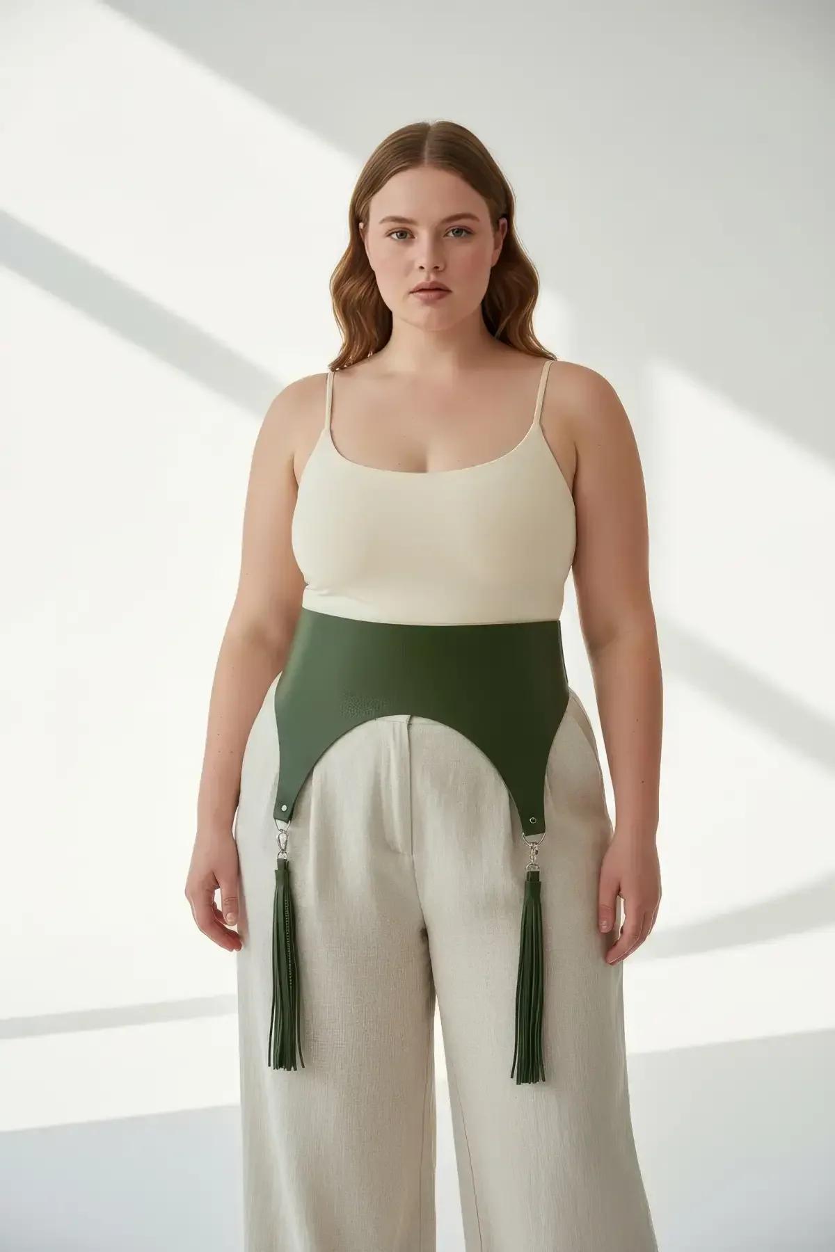 close-up of olive green vegan leather panel harness with silver D-ring tassel clips at lower front hem