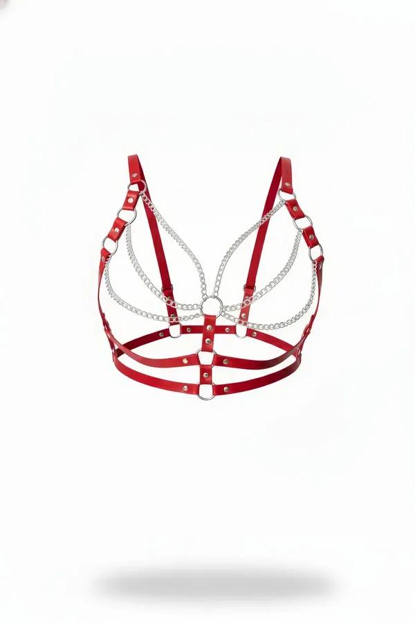 Red faux leather harness bra with cascading silver chain rows, O-rings, and adjustable straps on white background