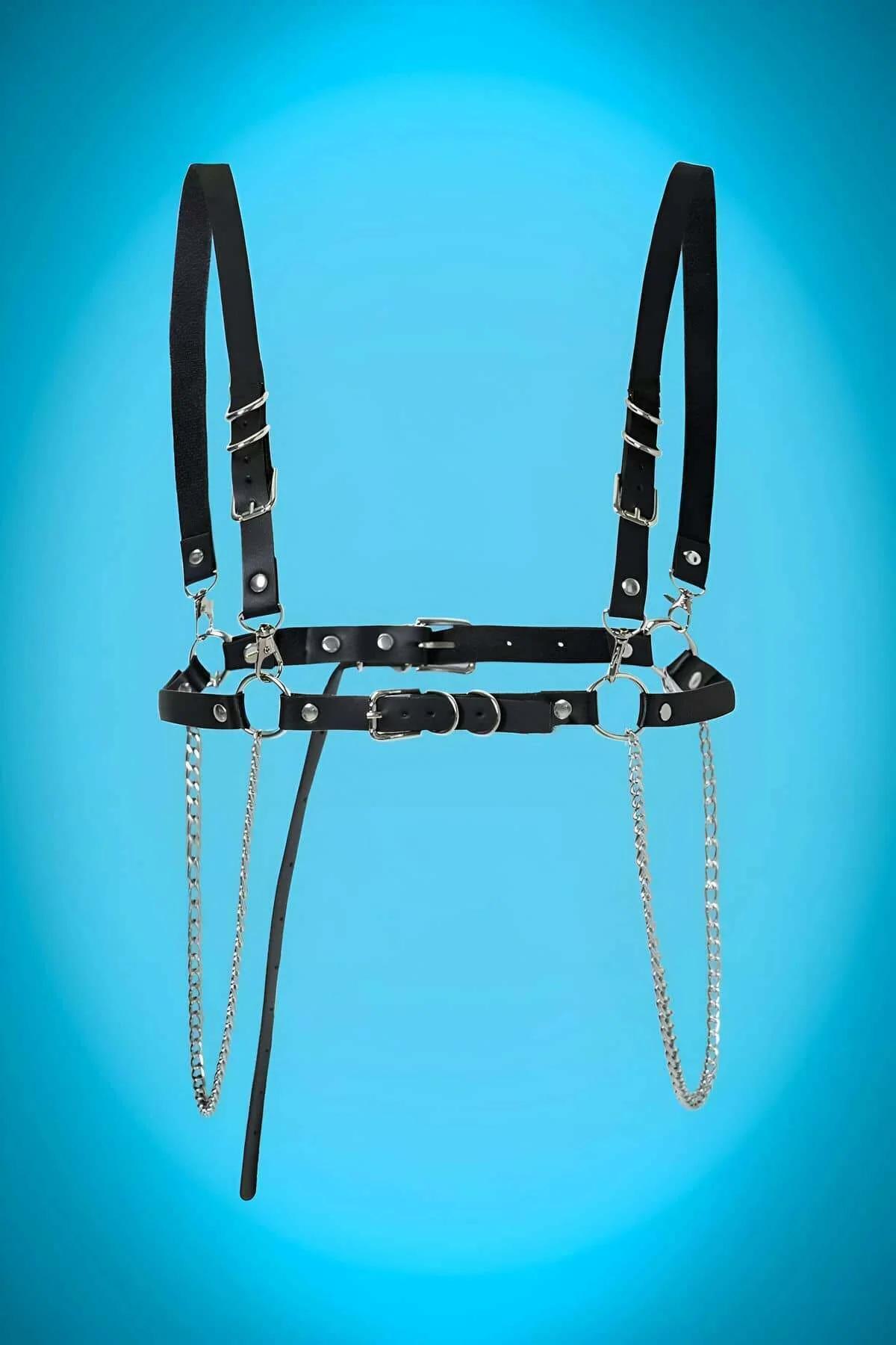 Close-up of silver lobster-claw clasp attaching chain to O-ring on black faux leather harness