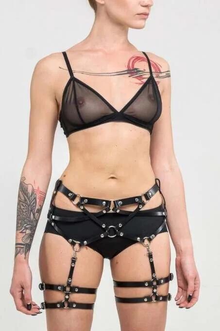 black faux leather multi-strap thigh harness with silver O-rings and pin buckles layered over hip and thighs