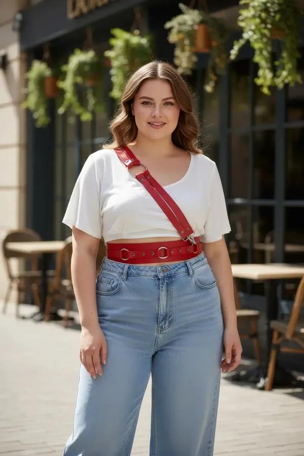 Red vegan leather O-ring waist belt harness with diagonal shoulder strap worn over white tee and jeans