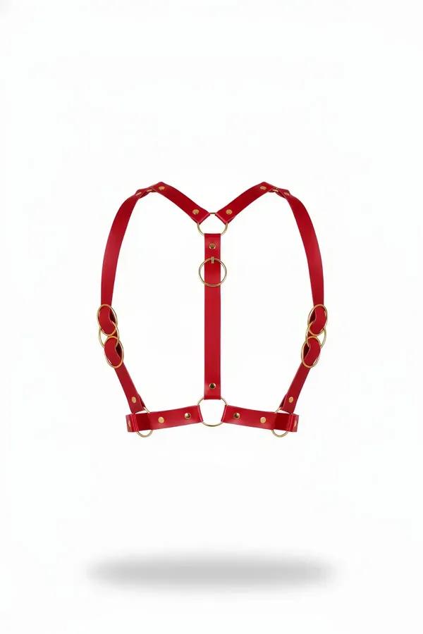 Red faux leather chest harness with five gold-tone O-rings and Y-shaped strap configuration, front view on white background