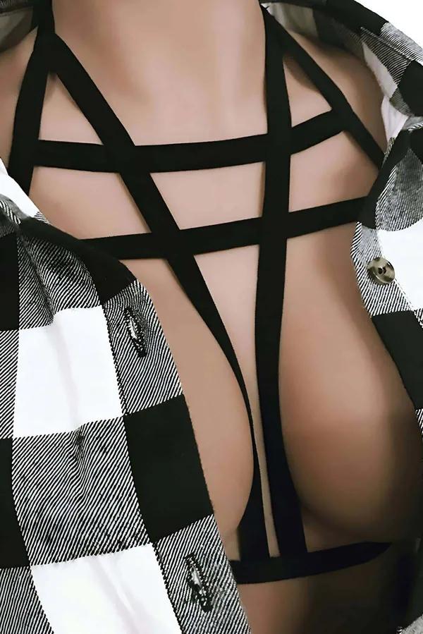 Black elastic strap geometric cross chest harness over plaid shirt