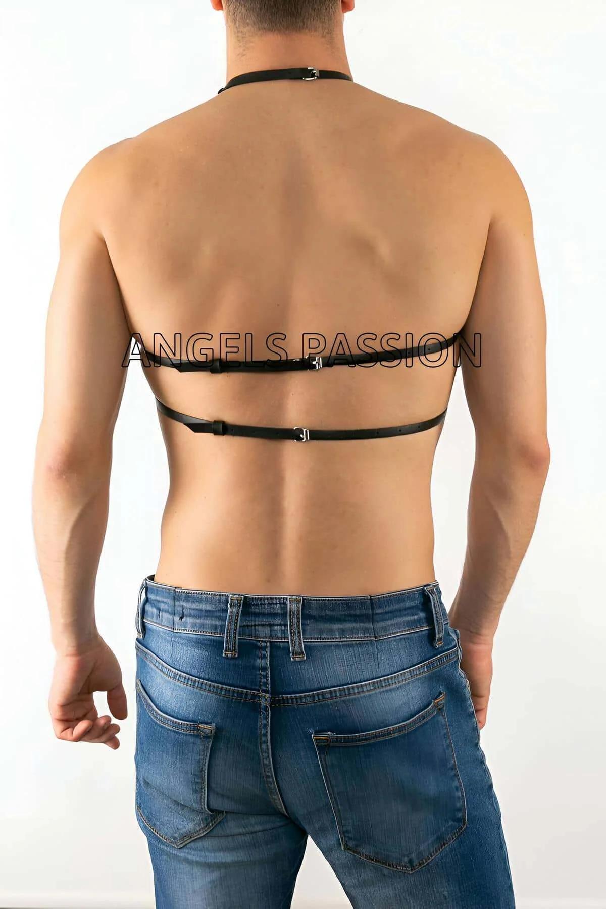 Close-up of silver O-ring junction on black faux leather diagonal cross-strap chest harness