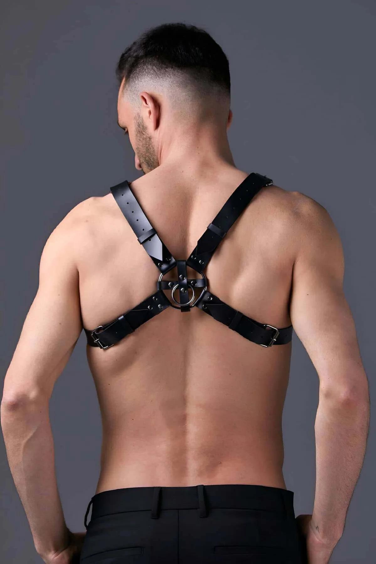 full torso view of black faux leather harness showing hip band and waist anchor connection