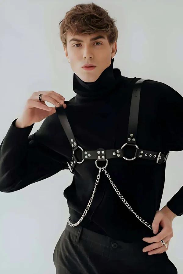 black faux leather full body harness with silver O-rings rivet-studded chest strap and detachable curb-link chain worn over b