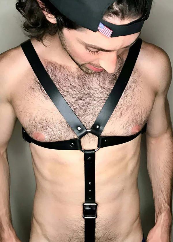 black faux leather chest harness with central O-ring silver buckle adjustable abdominal strap mens fashion accessory